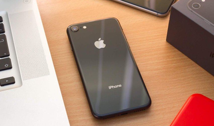 Iphone на столе возле техники apple
